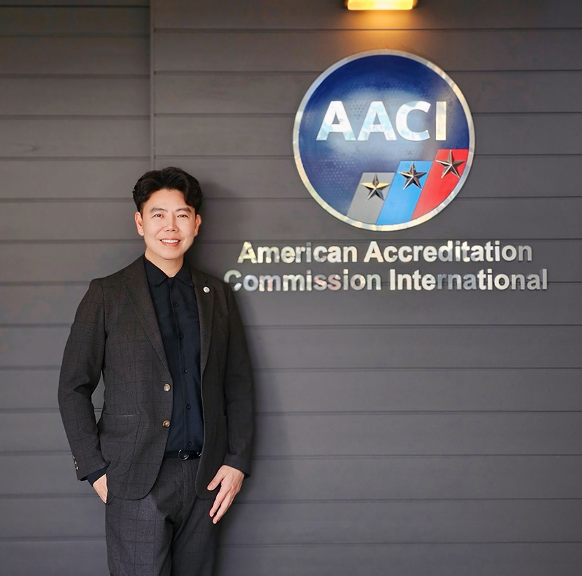 AACI representative standing beside the AACI logo